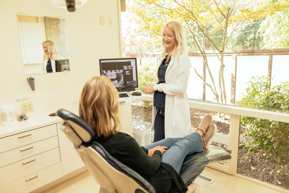 Dr. Whitney Forsythe speaking to a dental patient who is seated in an exam chair