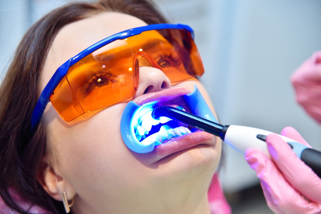 woman wearing protective glasses being treated with UV whitening lasers