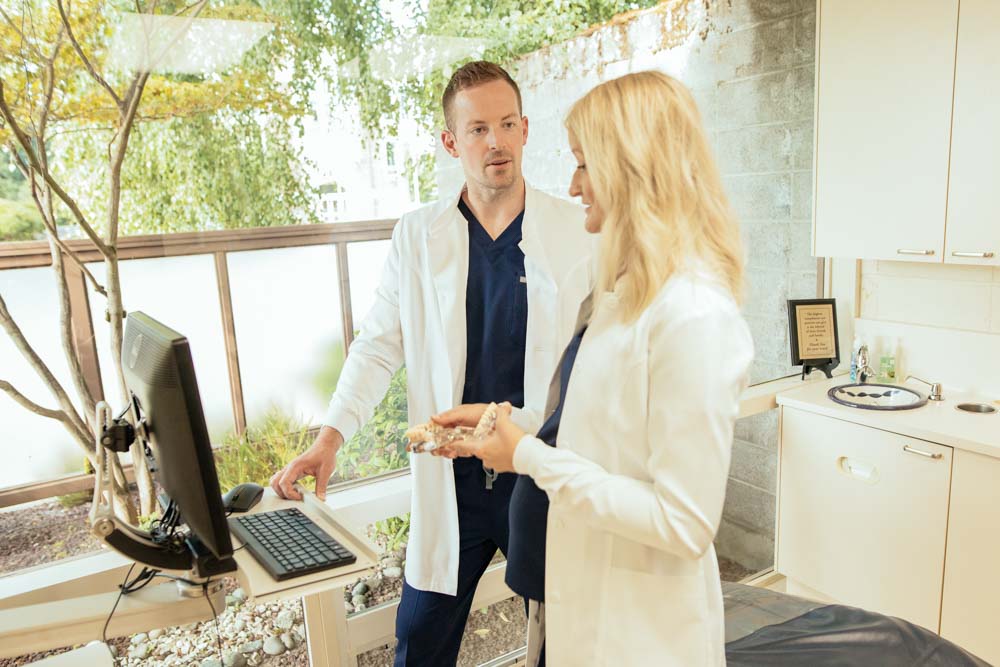 Drs. Nick and Whitney Forsythe discuss files on a monitor