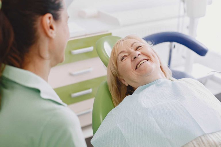 senior-aged female patient sitting at the dentist office