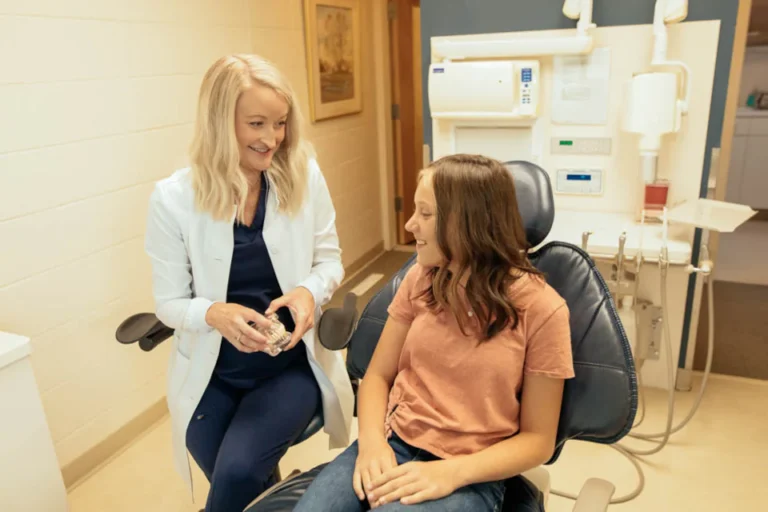 A dentist at Mount Vernon Smile Design in Mount Vernon, WA warmly discusses cosmetic dental care options with a young patient, creating a comfortable and reassuring experience.