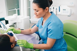 A pediatric dentist gently administers inhalation sedation to a child during treatment at Mount Vernon Smile Design, ensuring a calm and comfortable experience.